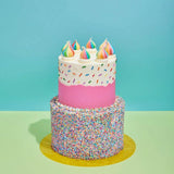 2 Tier Cake - Design Your Own with colorful sprinkles and rainbow cream swirls on pastel pink and white frosting.